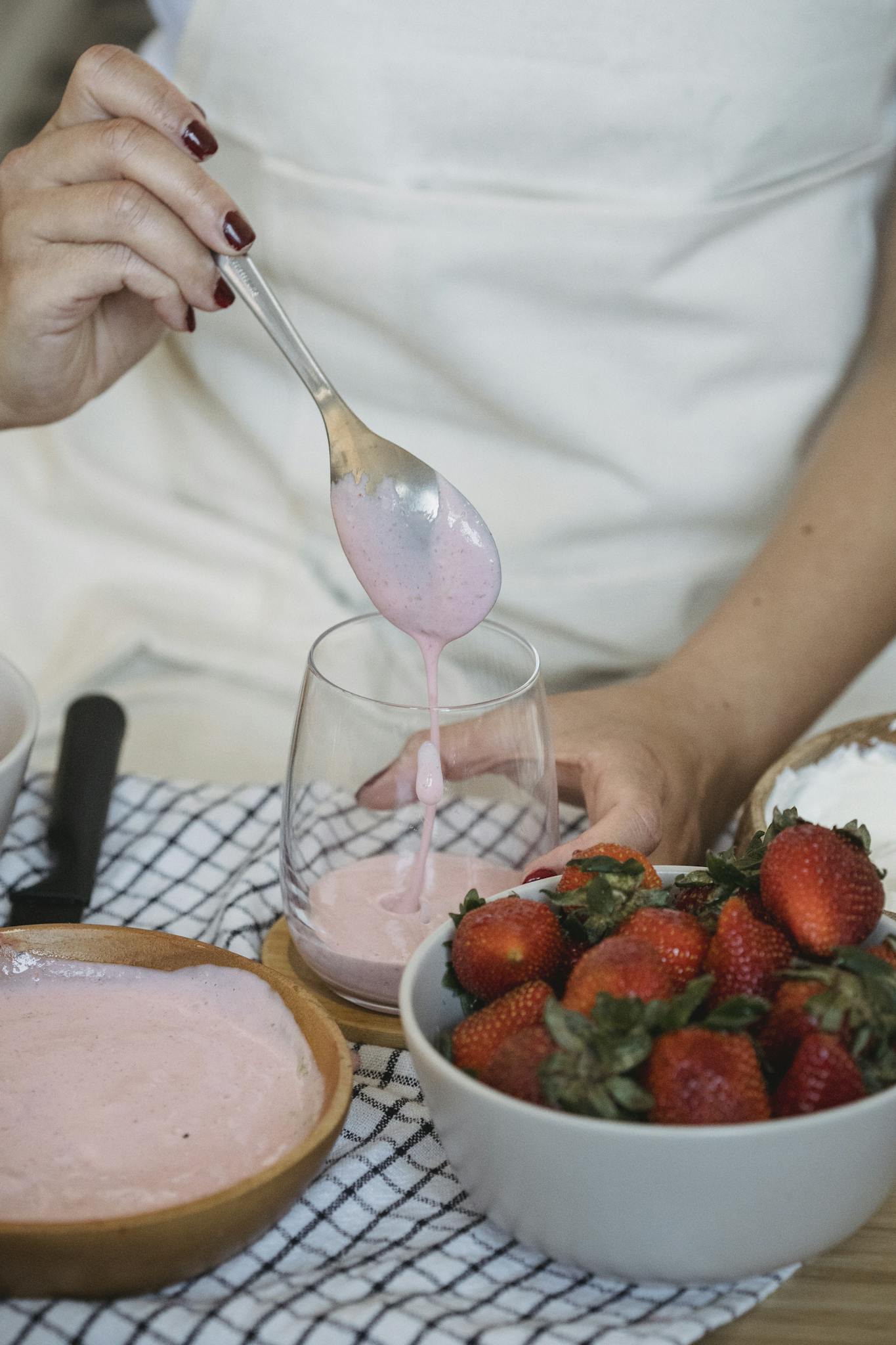Close-up of a strawberry smoothie being prepared with fresh strawberries and yogurt.